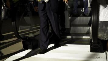 personas utilizando escalera mecánica a subterraneo estación. medios de comunicación. muchos hombres y mujer con pantalones Moviente abajo el escalera mecánica. foto