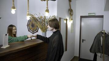 Young man check in at a hotel. Media. Happy receptionist giving a key to a man at the reception desk, concept of travelling. photo