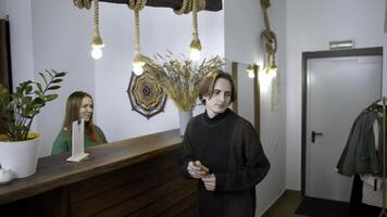 Young man check in at a hotel. Media. Happy receptionist giving a key to a man at the reception desk, concept of travelling. photo