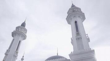 A white and gray historical mosque. Scene. Religious building with minarets on cloudy sky background. photo