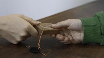 Passing small key with wooden number of a locker. Media. Close up of hands passing and taking a key. photo