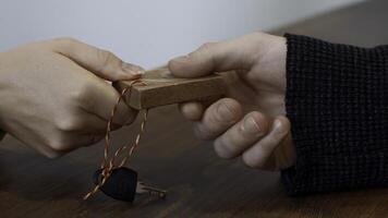 Passing small key with wooden number of a locker. Media. Close up of hands passing and taking a key. photo