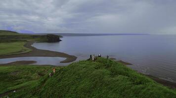 Aerial view of touristic group on a mountain top. Clip. People enjoying giant lake landscape. photo