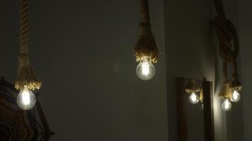 Burning stylish light bulbs decorated by ropes. Media. Stylish hanging bulbs, ethnic interior. photo