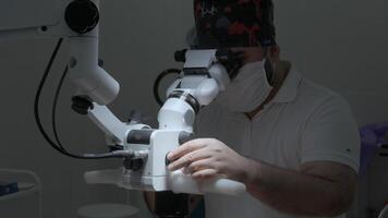 scienziato regolazione e ambientazione microscopio per microbiologia test nel laboratorio. azione. medicina scienza laboratorio ricerca concetto. video