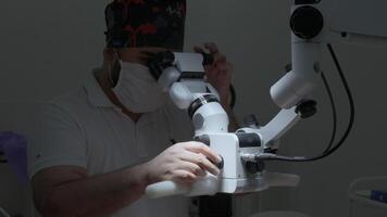 scienziato regolazione e ambientazione microscopio per microbiologia test nel laboratorio. azione. medicina scienza laboratorio ricerca concetto. video