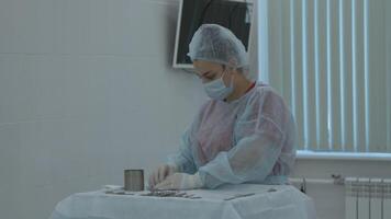 Preparation for the surgery. Action. Multiple surgery tools on the table in operating room, scrub nurse in rubber gloves. video