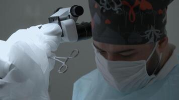 Medical worker performing surgery. Action. Concept of health care and medicine, doctor standing by microscope. video