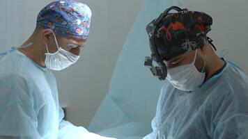 Betrieb Prozess mit zwei männlich Chirurgen untersuchen geduldig. Aktion. Ärzte beim ein Krankenhaus. video