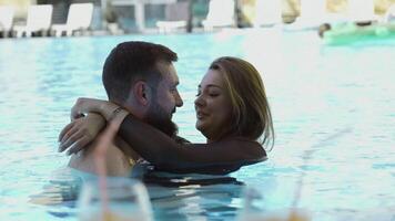 feliz casal abraçando dentro ao ar livre natação piscina. grampo. homem e mulher em uma período de férias. video