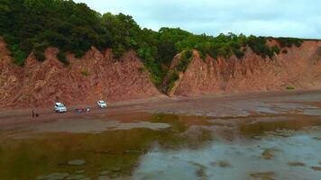 Top view of coast with tourists and rocky gorge. Clip. Amazing coast with rocks and tourists at gorge. Forest gorge on shore of rocky cliff with tourists video