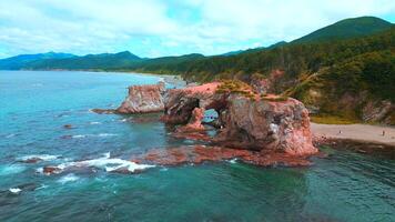 Top view of beautiful coast with rocky arches. Clip. Amazing nature of erosion in sea rocks on coast. Wild beach with coastal cliffs and stone arches video