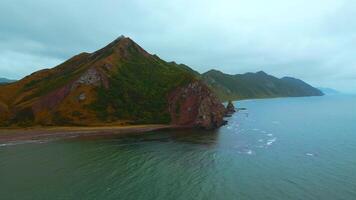 Top view of mountain coast with rocks on cloudy day. Clip. Beautiful landscape of sea and mountain island in cloudy weather. Fascinating landscape of northern coast with sea and rocks video