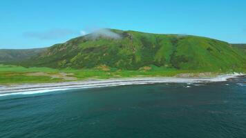 Aerial view of summer green meadows and mountains at the edge of the sea on the Isle of Skye, Scotland. Clip. Concept of summer nature. video