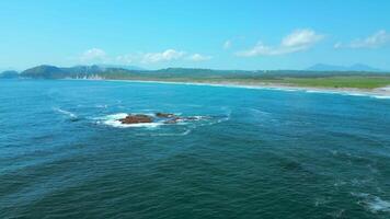 Aerial picturesque seascape with blue water, boulders rising up above sea surface. Clip. Summer coastline and blue sky above. video