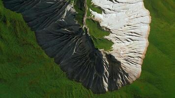 Top view of picturesque mountain peak. Clip. Frozen stone formations and green grass. video