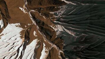 Aerial top view of the mysterious mountain rocks. Clip. White stone layers and brown ground. video