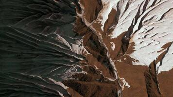 aéreo parte superior ver de el misterioso montaña rocas acortar. blanco Roca capas y marrón suelo. video