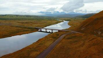 Aerial view of gorgeous nature a bridge between the river shores. Clip. Rural landscape with golden agricultural fields around and the sea shore. video