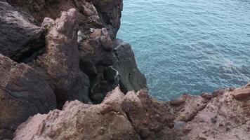 schön Felsen durch Wasser. Clip. Stein Klippen von Küste mit ruhig Meer Wasser. Aussicht von Kante von Stein Ufer zu Meer Wasser video