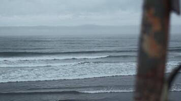 Detail of deck on background of sea on cloudy day. Clip. Blurred rusty part of abandoned boat on background of sea horizon. Beautiful sea with waves on cloudy day video