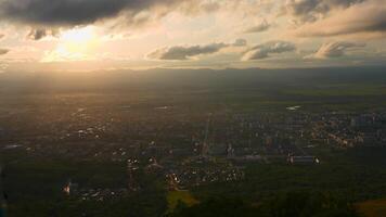 oben Aussicht von Stadt im Grün Senke mit Sonne auf Horizont. Clip. schön Landschaft von sonnig Grün Senke mit Stadt, Dorf auf Sommer- Tag. hell Sonne scheint Nieder auf Senke mit Stadt, Dorf video