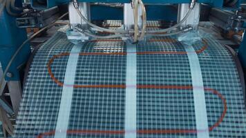 Industrial production of plastic nets. Creative. Industrial machine laying heat wire on polymer grid. Production of polymer modules for thermal floors video