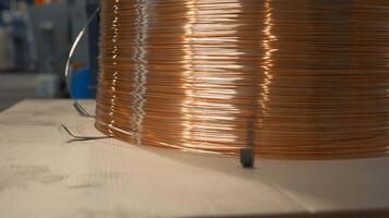 Close-up of wound copper wire in production. Creative. Thin line of wire on industrial coil. Production of copper wire at metallurgical plant video