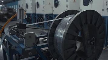 Metal long narrow sheets wraping on a bobbin. Creative. Large spool in a factory workshop, industrial background. video