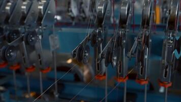 Close up of many small steel wire coils at the factory. Creative. Industrial background with thin wires stretching from the spinning spools. video