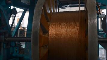 Rotating coils with metal wires at factory. Creative. Winding of metal fiber on bobbins at metallurgical plant. Process of twisting into coils of copper wire on industrial scale video