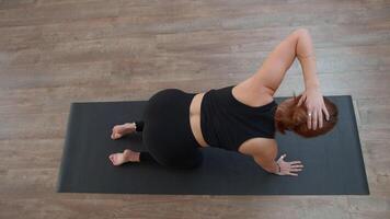 un mujer desde un rodilla codo posición haciendo el enfermedad de buzo de el cuerpo. medios de comunicación. concepto de deporte y cuerpo cuidado. video