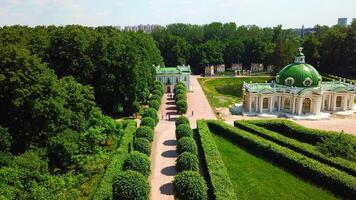 top visie van mensen wandelen Aan gebied van paleis tuin. creatief. mooi weg van paleis tuin met mooi struiken en bomen. oud gebouw van Koninklijk landgoed met tuin Aan zonnig zomer dag video