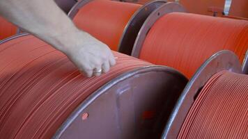 detailopname van arbeider met draden Aan wikkelen in fabriek. creatief. arbeider getallen wikkelen met draden Bij fabriek. kant en klaar wikkelen met rubber draden in industrieel onderneming video