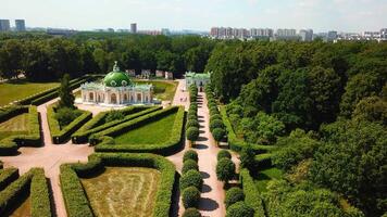 Top view of people walking on territory of palace garden. Creative. Beautiful road of palace garden with beautiful bushes and trees. Old building of royal estate with garden on sunny summer day video