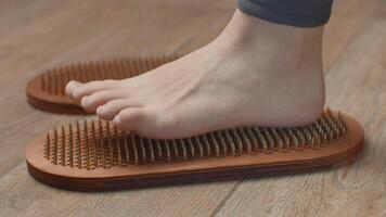 Female feet standing on boards with nails, close up. Media. Barefoot female standing on yoga nails board. video