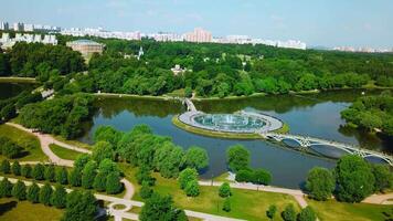 Top view of bridges in city pond with fountains. Creative. Island with bridges and fountains in city pond. Beautiful fountain complex on river island with pedestrian bridges video