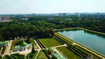 paleis met vijver Aan achtergrond van modern stad. creatief. top visie van mooi historisch complex Aan zonnig zomer dag. vorstelijk gebouwen met tuin en vijver met contrast van modern stad Aan horizon video