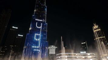 DUBAI - UAE, APRIL 3, 2023. Dancing fountains at Dubai Mall near Burj Khalifa. Action. Beautiful fountain performance at night in popular tourist area. video