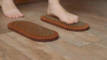 Wooden sadhu board for standing on nails, indoors yoga practice. Media. Woman feet trying to stand on nails. video