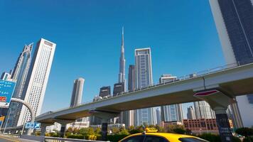 Dubai stad met straat en brug met het rijden auto's. actie. Doorzichtig blauw lucht en wolkenkrabbers van de stad centrum. video