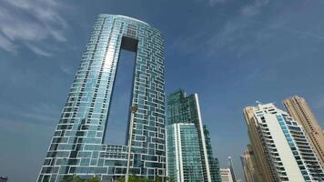 Low-angle view of the Address Beach Resort, Dubai, United Arab Emirates. Action. Beautiful skyscraper with a rectangular shaped hole in building. video