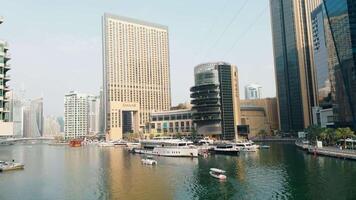 ein Aussicht von das schön Stadt von Dubai und das Wasser Kanal. Aktion. Segeln Boote und sonnig Damm. video