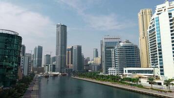 panorámico ver de alto edificios con vaso fachada. acción. real inmuebles negocio en unido árabe emiratos y agua canal. video