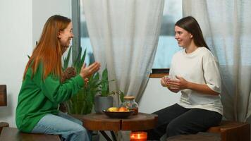 hermosa joven mujer son activamente hablando en cafetería. medios de comunicación. amigos son teniendo divertido hablando en acogedor estudiante cafetería. amigos bebida té y tener divertido chateando en estudiante descanso video