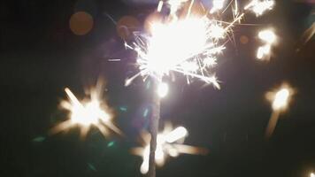 Beautiful sparkler on shiny background, close up. Christmas and new year party sparkler on bokeh background. Close-up view of lit up holiday sparkler video