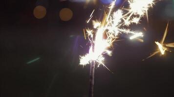 Beautiful sparkler on shiny background, close up. Christmas and new year party sparkler on bokeh background. Close-up view of lit up holiday sparkler video