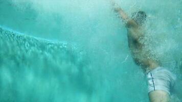 Man jumping into swimming pool. Scene. Underwater video shooting. Swimmer jumps into the water in the pool