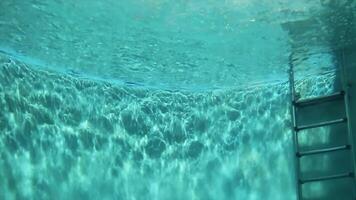 Blue water inside. Scene. Footage of blue swimming pool as seen from underwater, ideal for use as a background in your projects. Under Swimming Pool in hotel with ripple and wave shadow with video