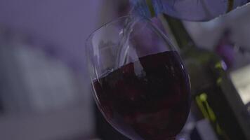 Glass of red coctail with red fruits near the bottle of wine. Frame. Close up video